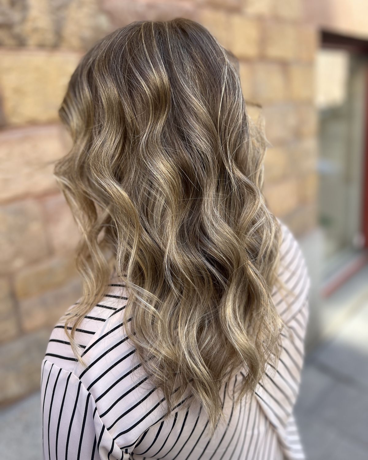Balayage med mjuka vågor i ljusa och mörka blonda toner